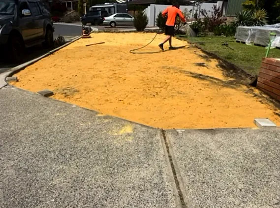Driveway during preparation, a screeded bed of yellow sand ready for pavers