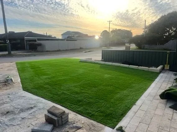 Same front yard covered in fresh green roll-on turf at sunset