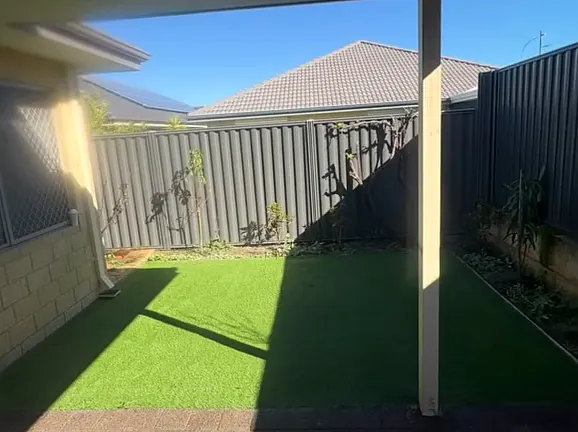 Synthetic lawn in a fenced backyard